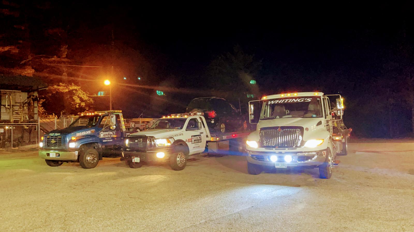 Whiting's tow trucks lined up at night in Ossipee, NH