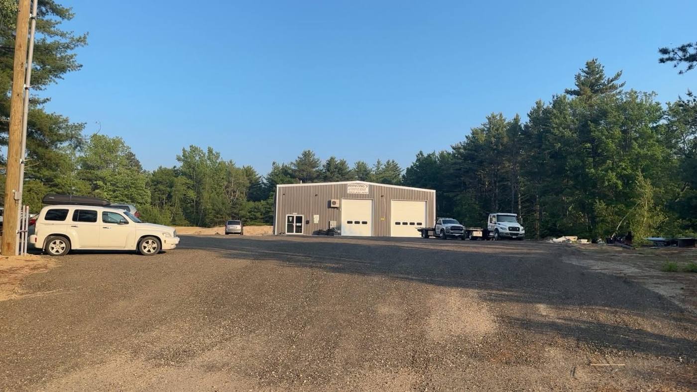 Whiting's flatbed and wrecker parked at the Ossipee shop