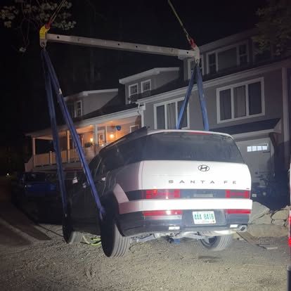 Whiting's rotator lifting a Hyundai Santa Fe on rigging straps at night